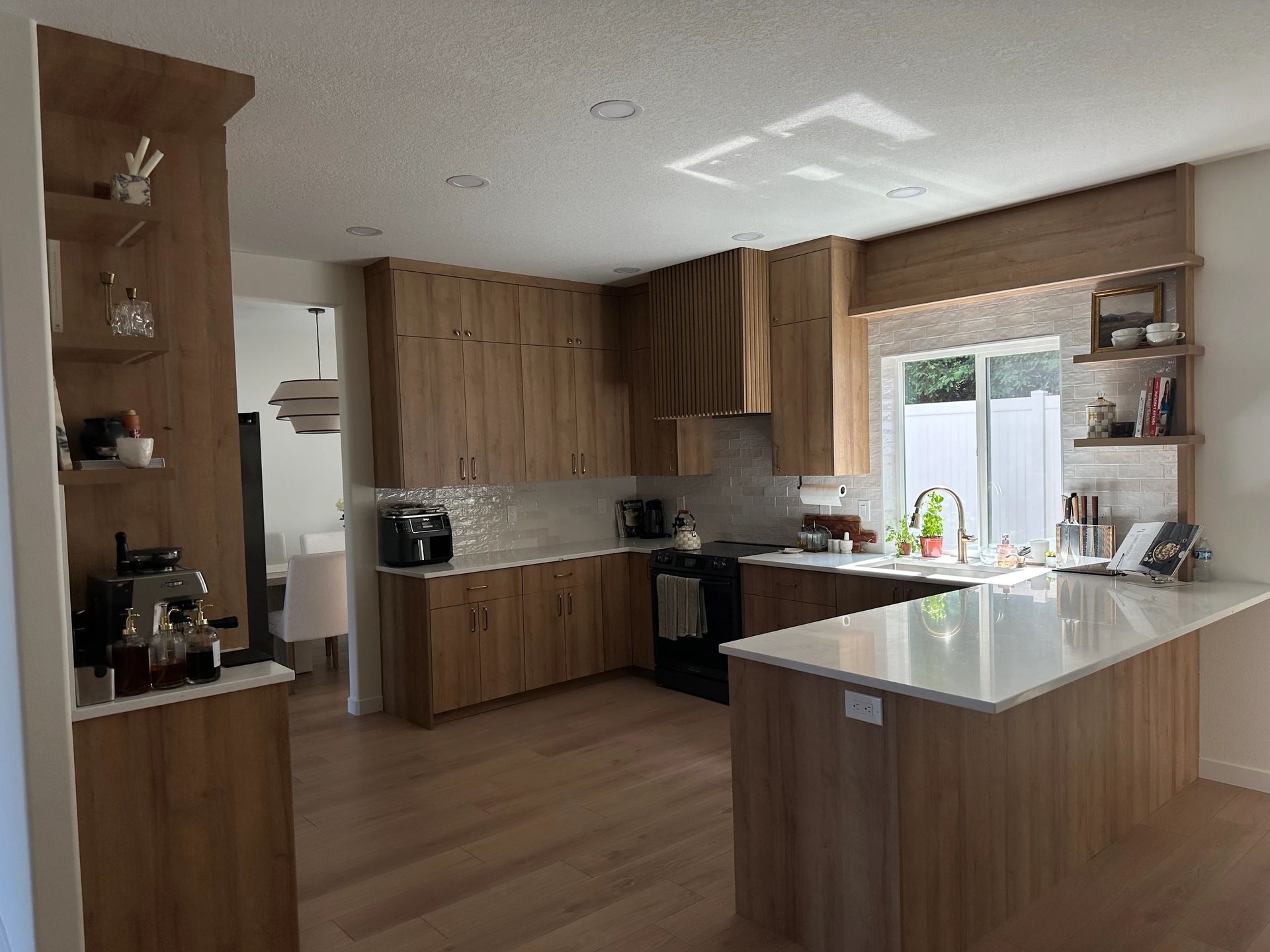 Modern kitchen with wooden cabinets, white countertop, and island.