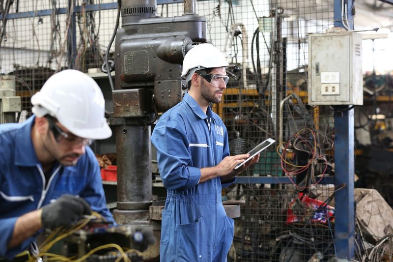 Two men are working in a factory and one is using a tablet. - Old Hickory, Tennessee - Music City Electricians LLC