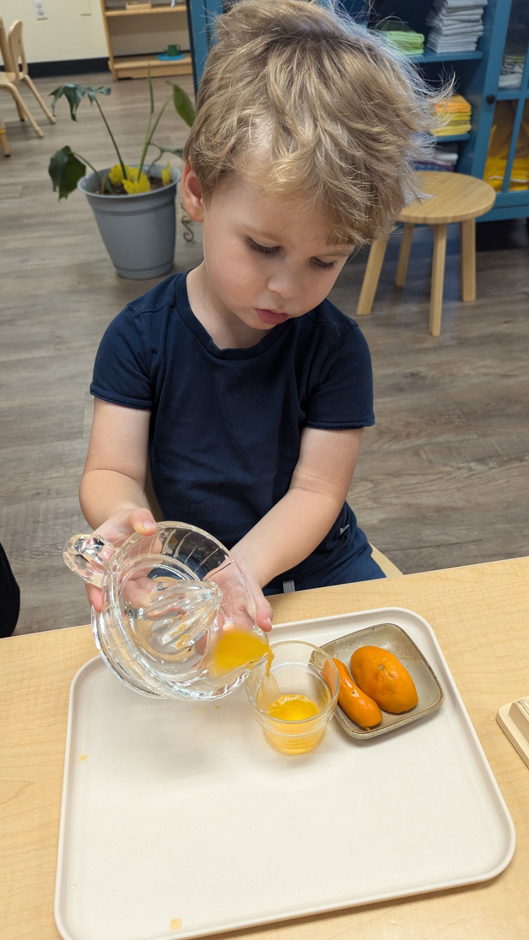 A little girl is holding a montessori music material in her hands and smiling.