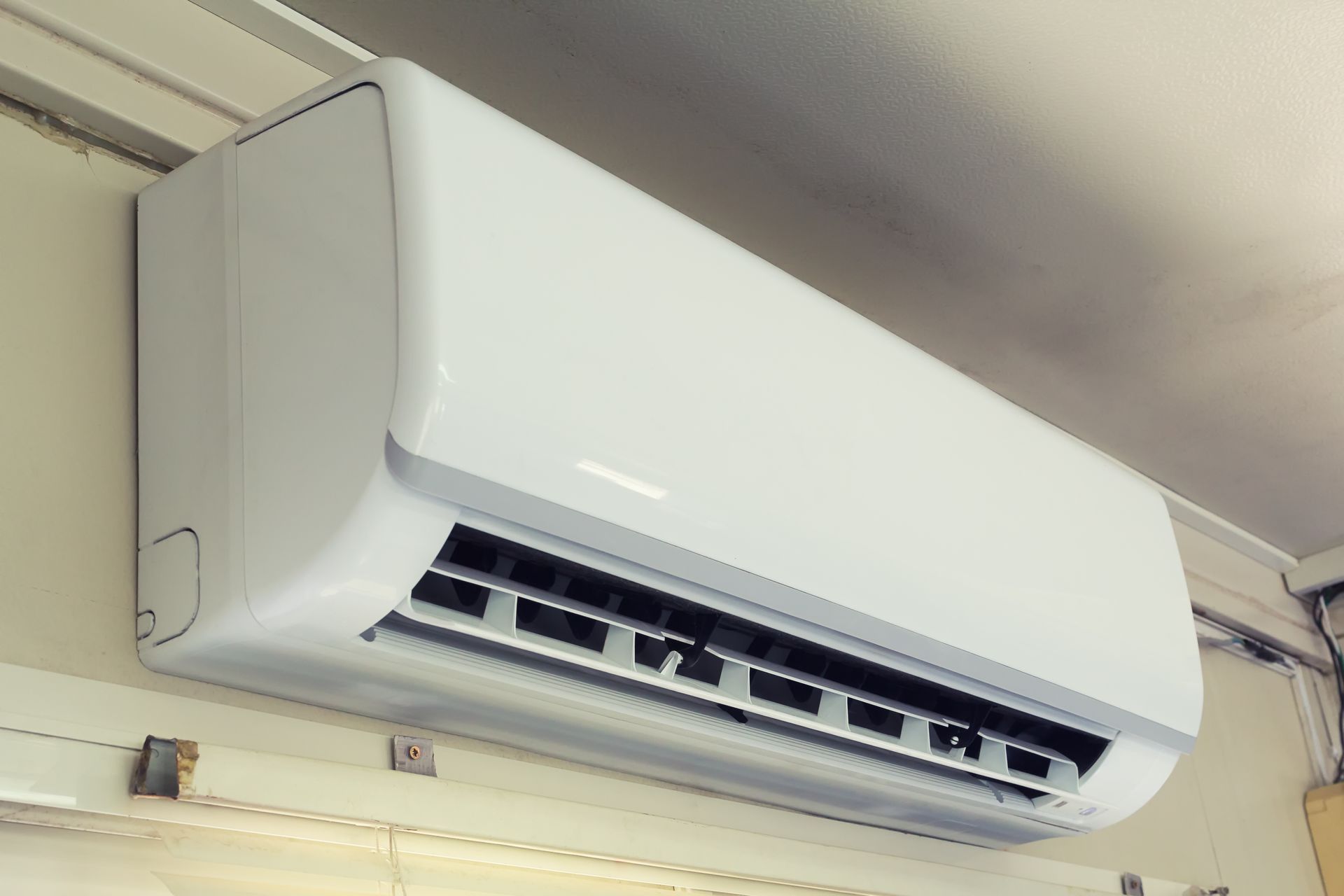 A white air conditioner is hanging on a wall.