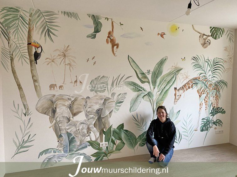 Asiya zit voor een muurschildering met jungle thema met een olifant een giraffe en een aapje slingert in boom