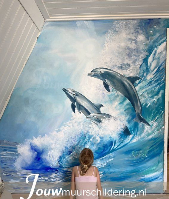 muurschildering dolfijnen in golf met kind die naar schildering kijkt