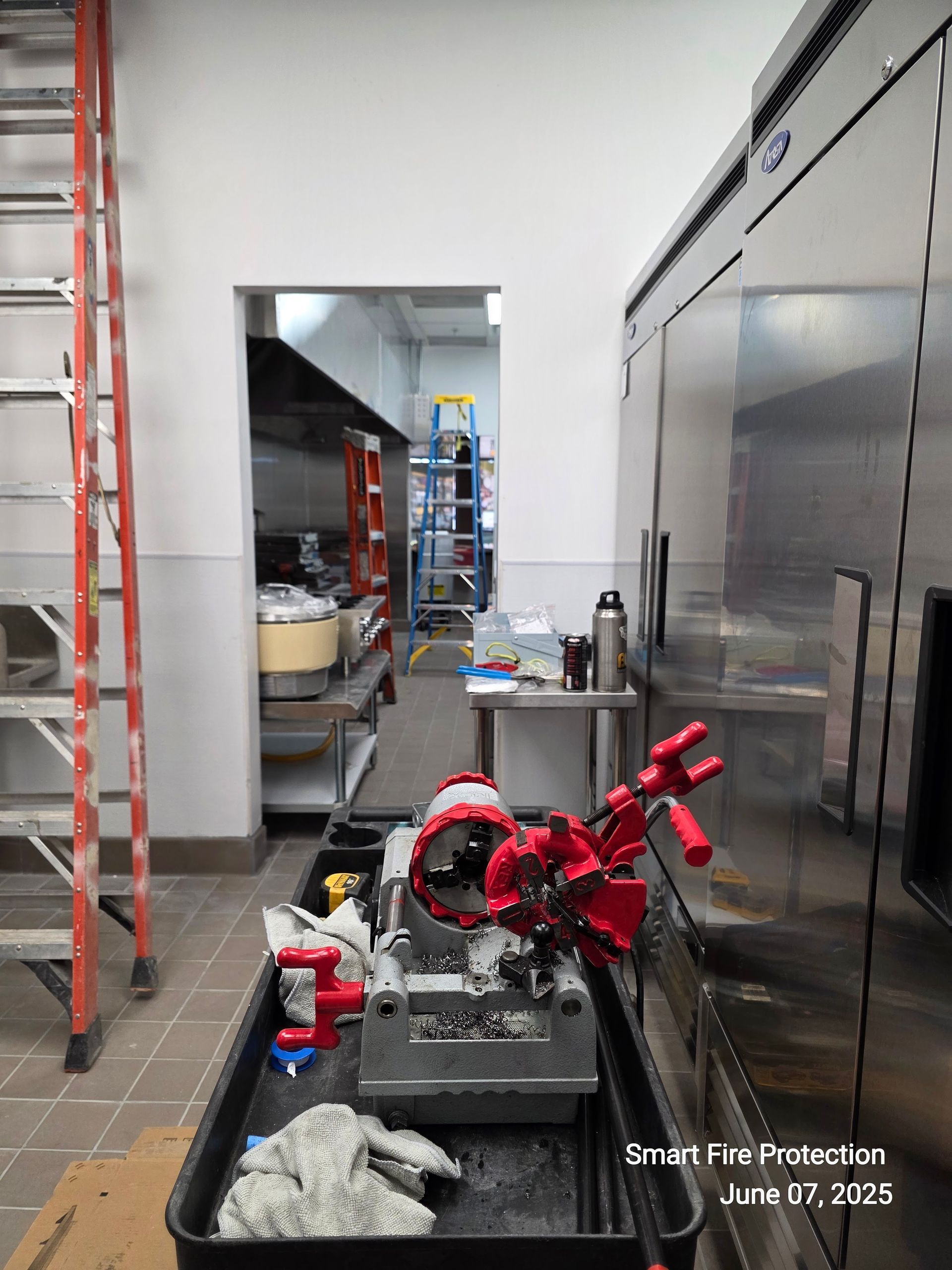 Kitchen interior: Red ladder, stainless steel appliances, food prep area, doorway leading to kitchen.