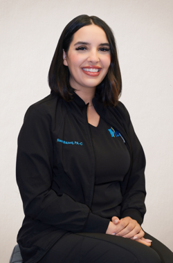 The woman is wearing a black jacket and smiling for the camera.