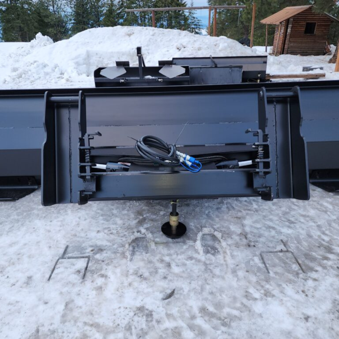 A snow plow is sitting in the snow near a pile of snow