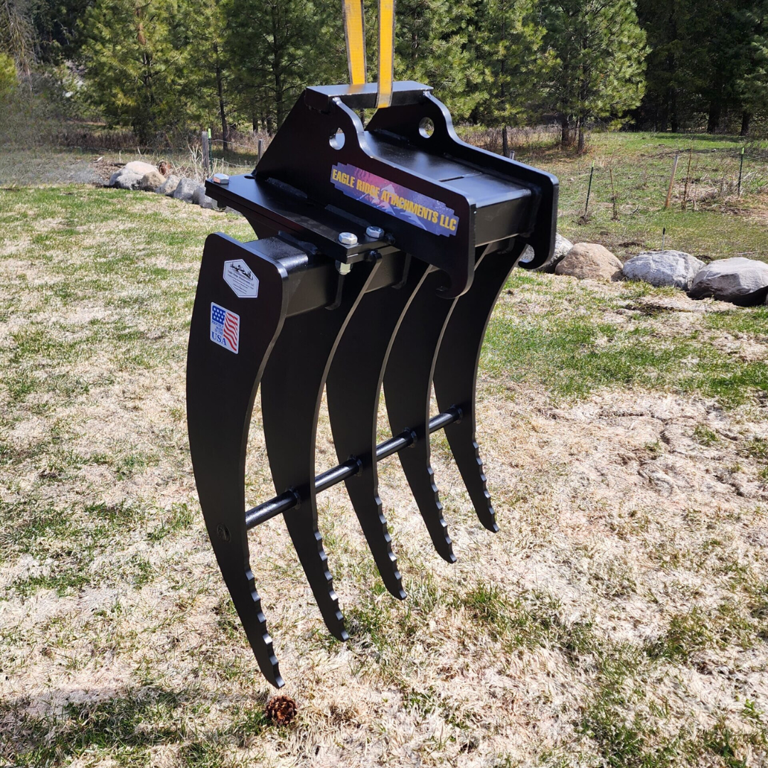 A black rake is sitting on top of a dirt field.