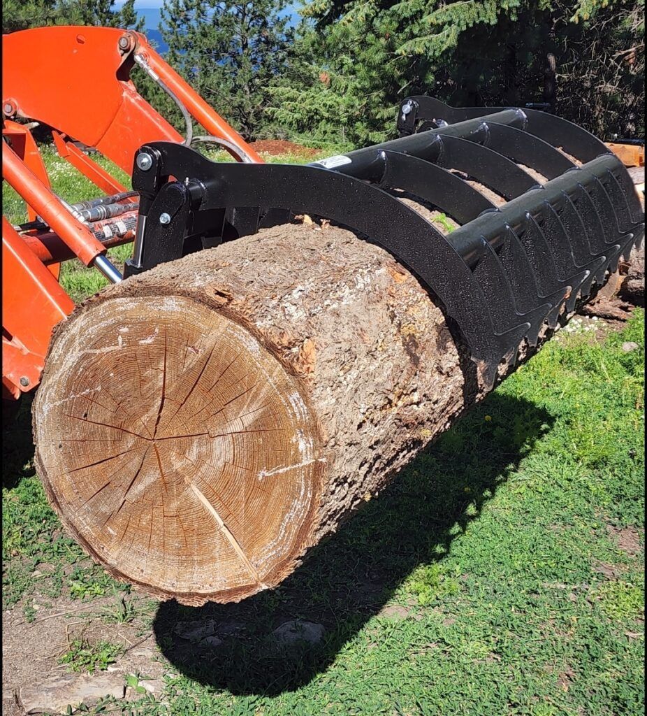 A large log is being lifted by a tractor