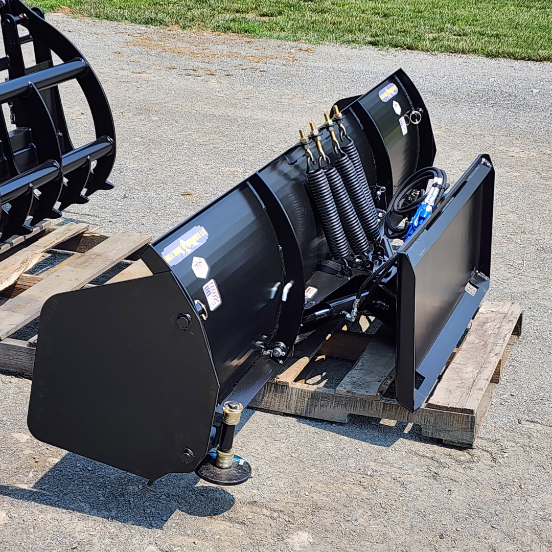 A black snow plow is sitting on top of a wooden pallet.