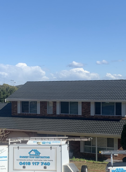A House with a Dark Roof and a Truck parked Outside — Norwest Roof Restorations In Central Coast, NSW