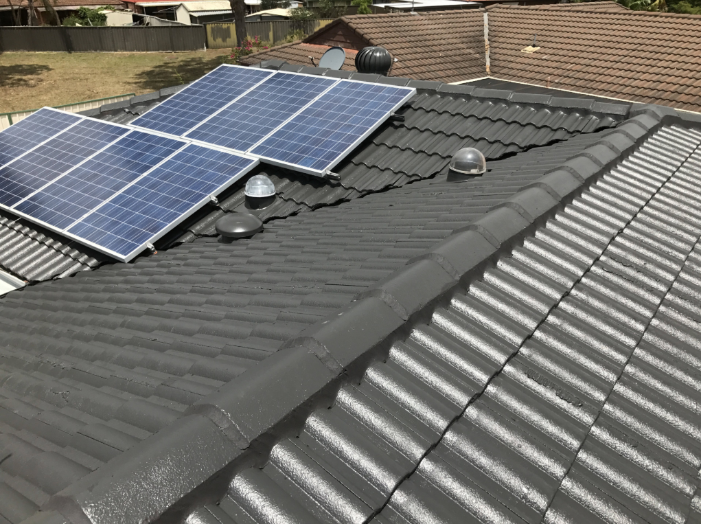 A Row of Solar Panels Sitting on Top of a Tiled Roof — Norwest Roof Restorations In Central Coast, NSW