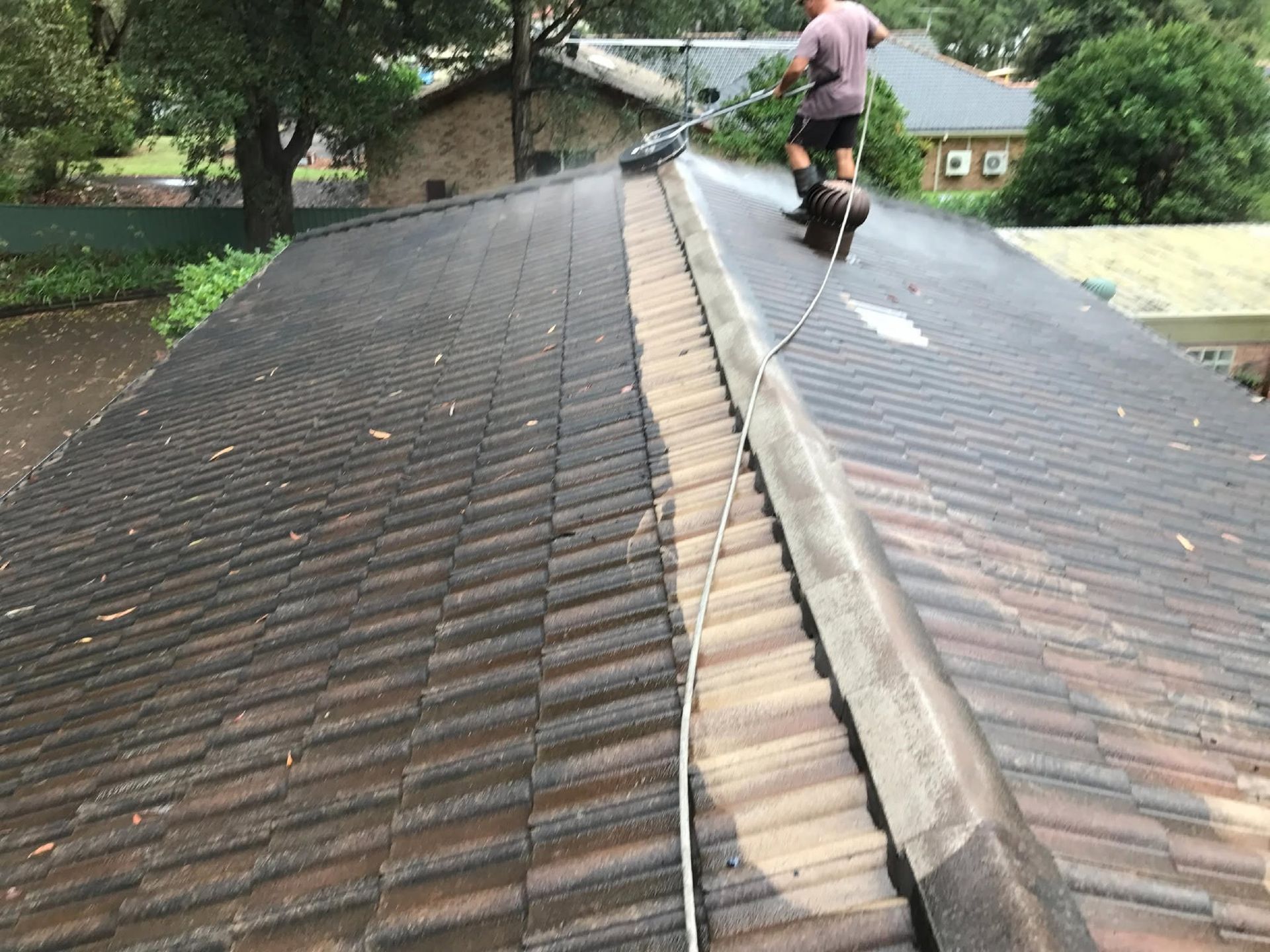Worker Pressure Washing a Roof in Gosford