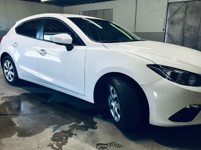 Red Ford F-150 truck with black grill and silver wheels parked outdoors. Texas license plate.