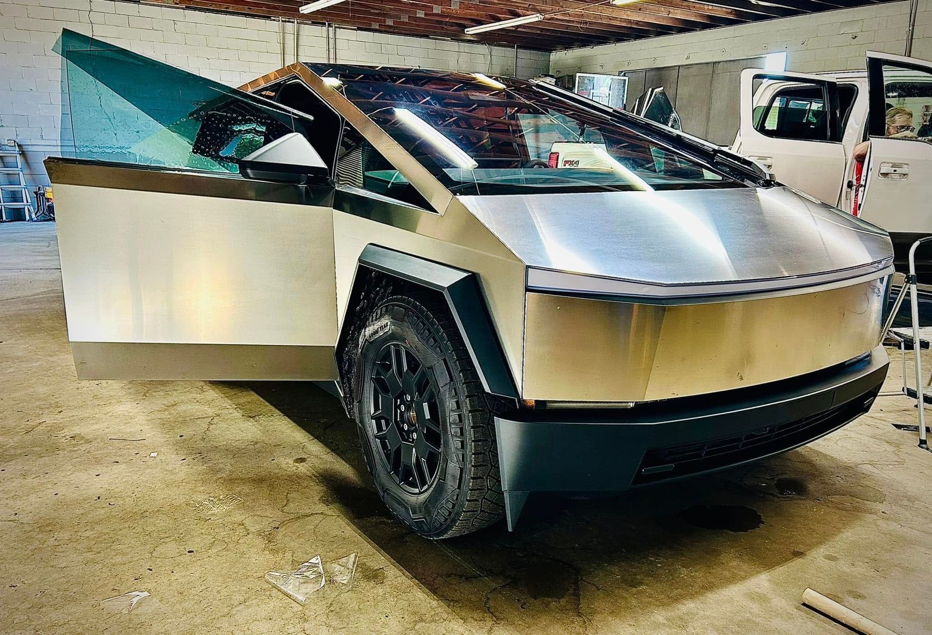 Tesla Cybertruck with the door open, in a garage.