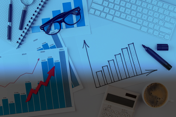 Business financial data charts, keyboard, coffee, and office supplies.