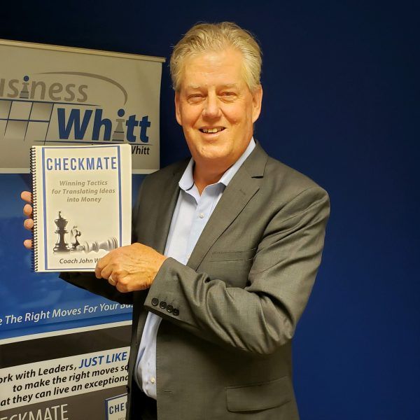 Man in suit holding a book titled 