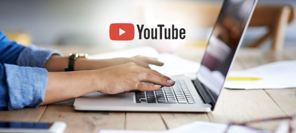 Person typing on a laptop with YouTube logo overlaid.