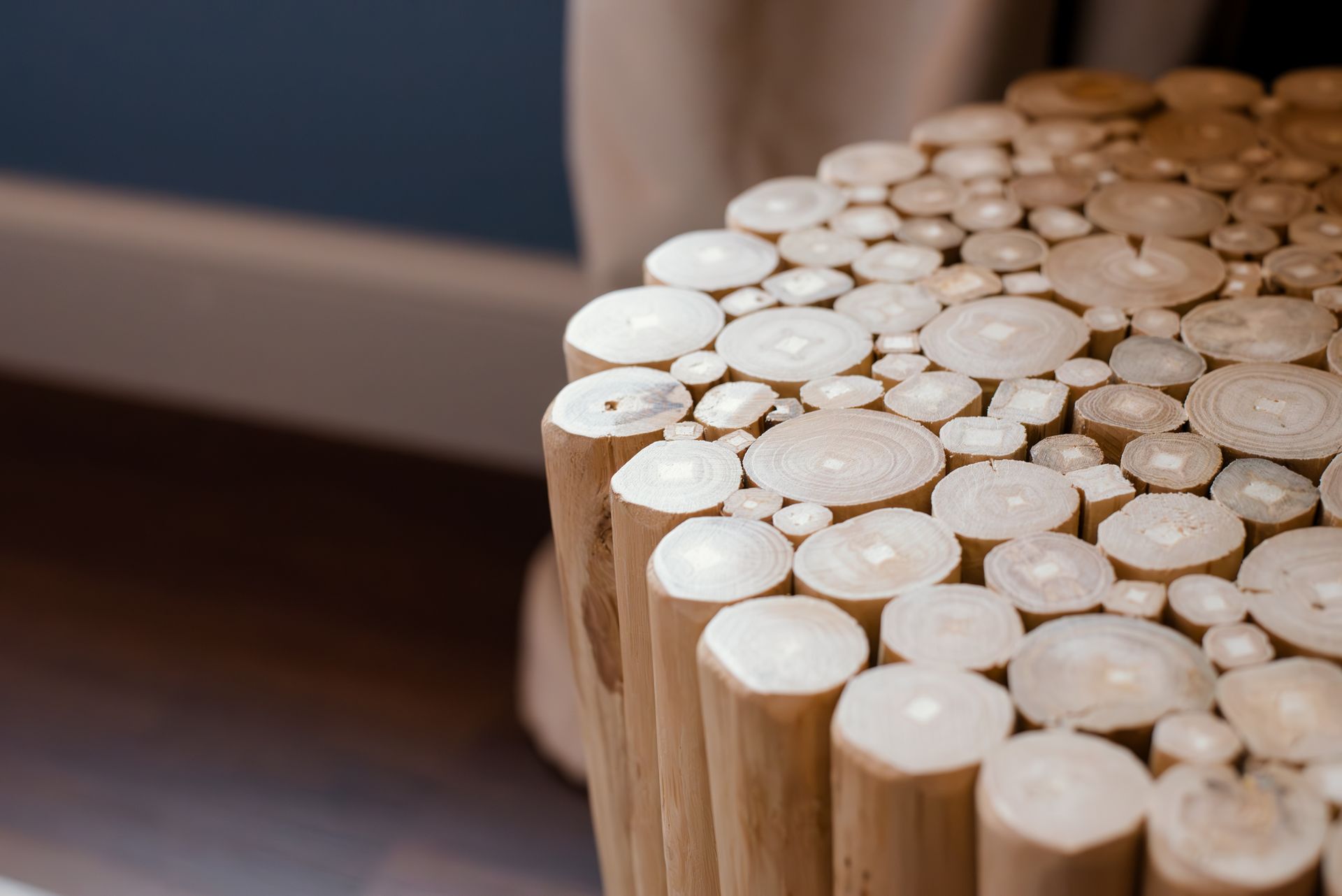 Wooden side table made of multiple log ends, beige color.