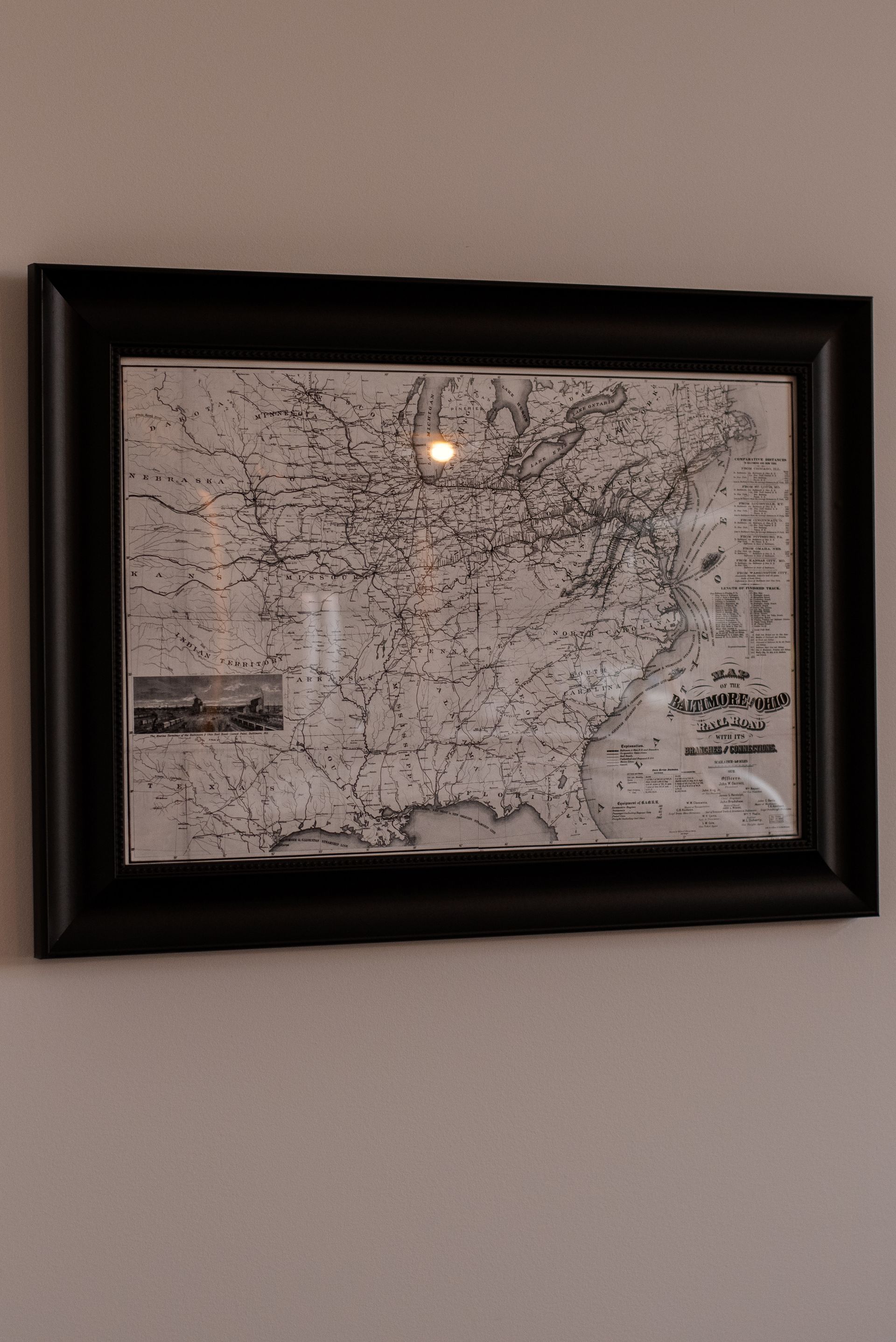 Framed black and white map of the United States hanging on a light-colored wall.