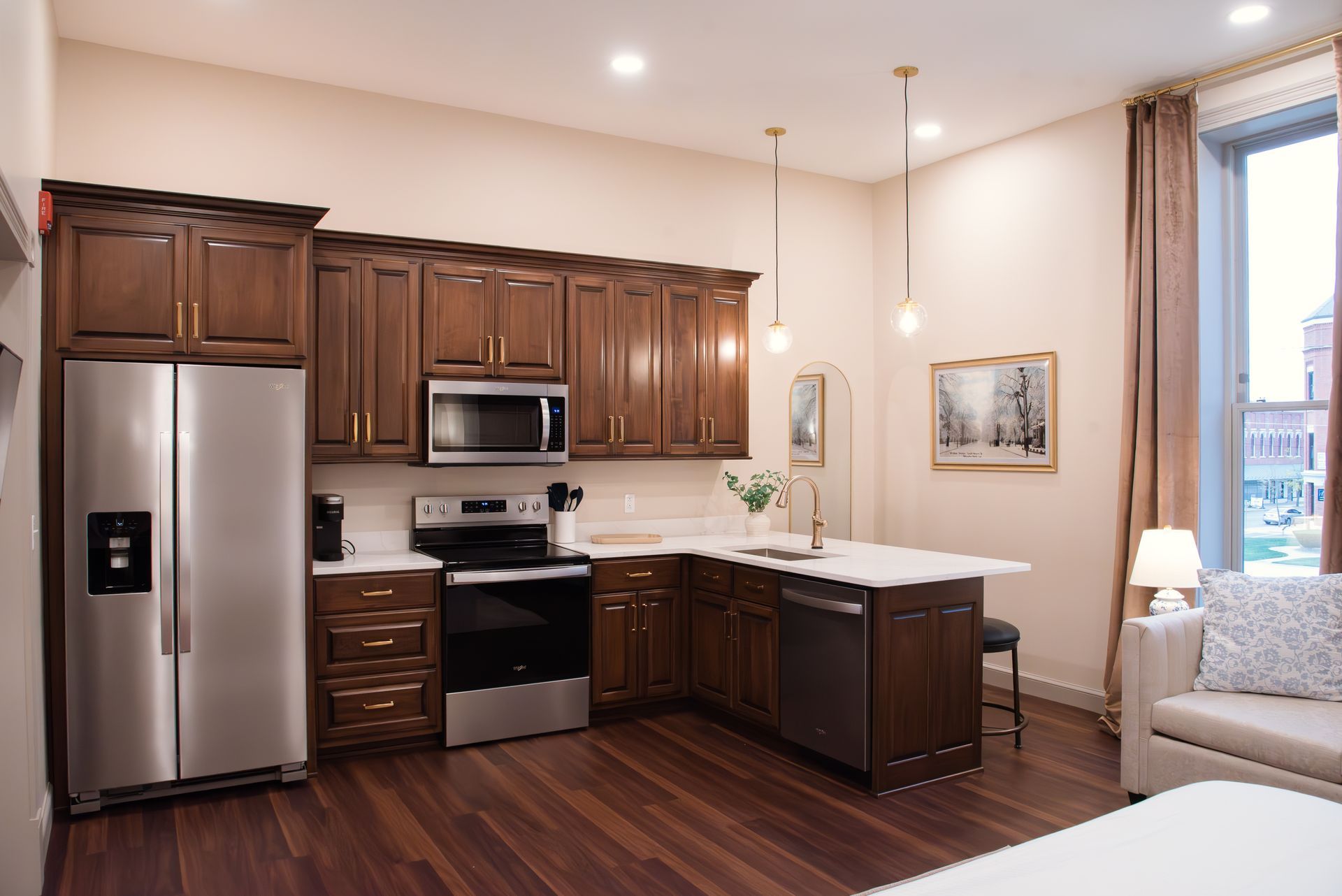 Kitchen with stainless steel appliances, dark cabinets, and a white countertop island.