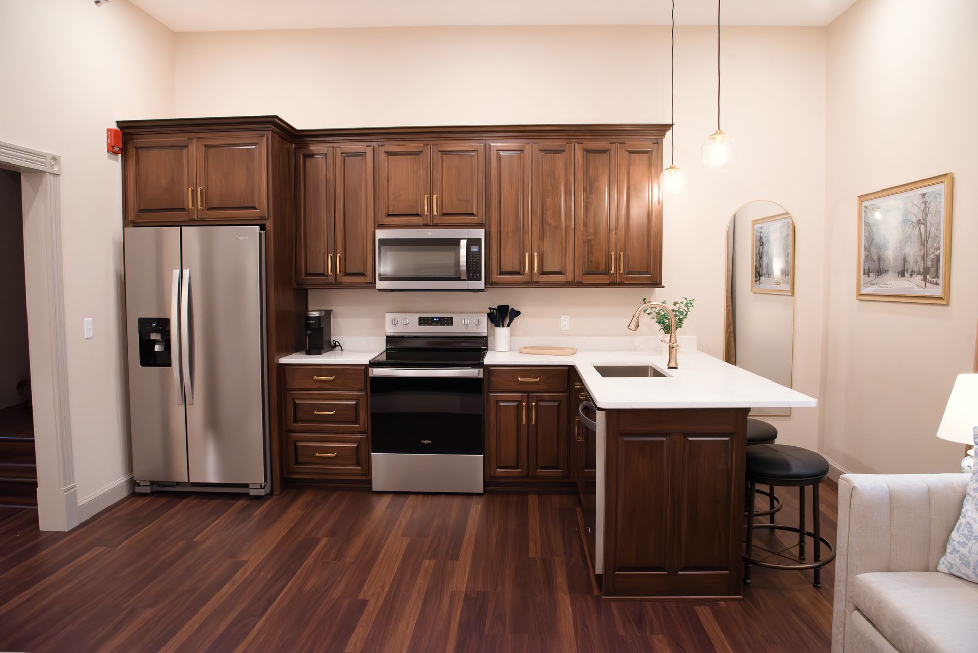 Kitchen with dark wood cabinets, stainless steel appliances, and a white countertop island.