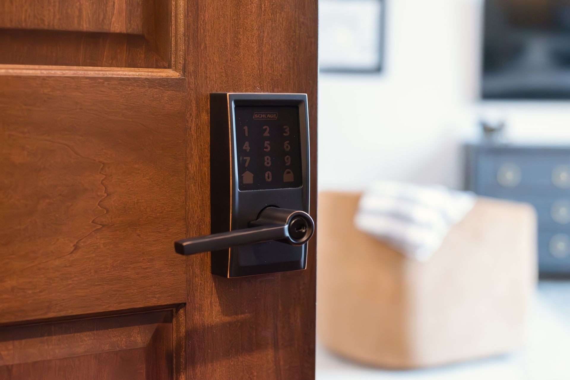 Door with smart lock open, revealing an interior with furniture and a towel.