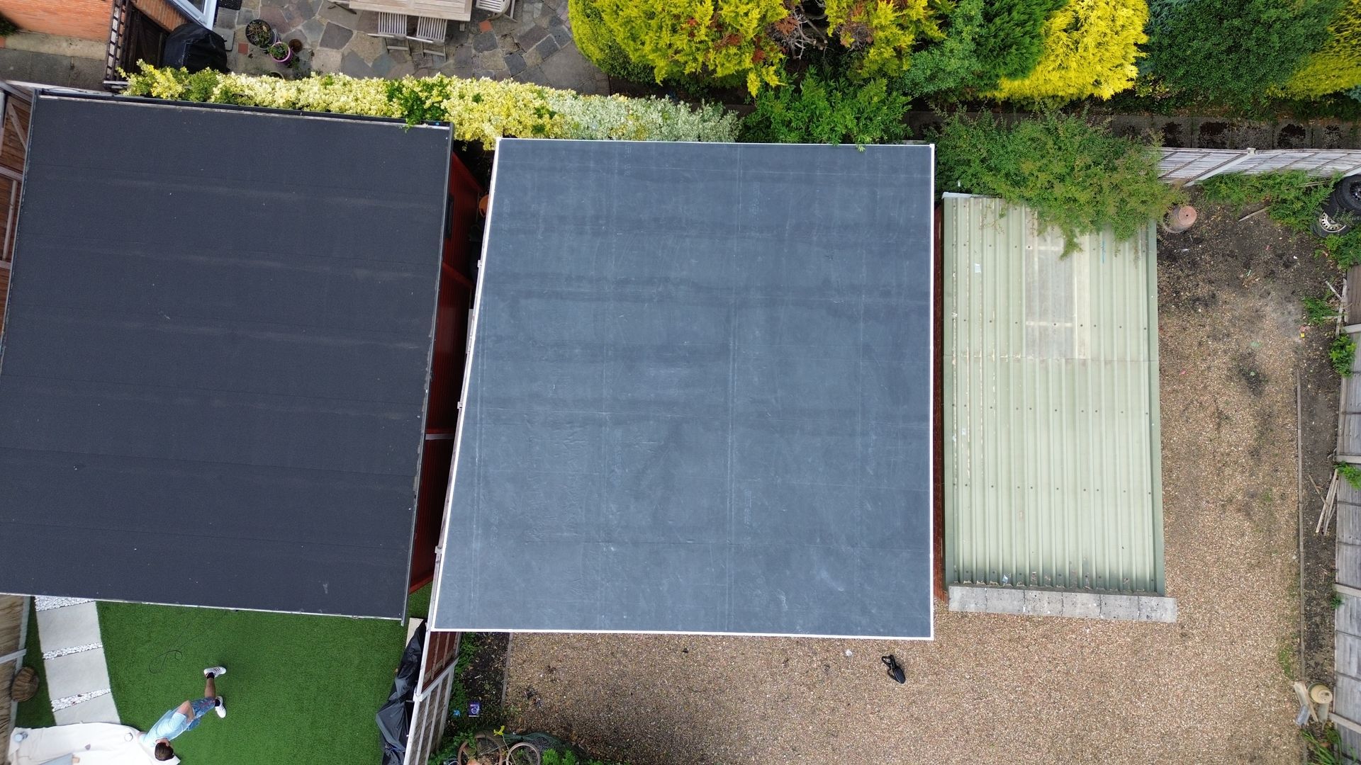 an aerial view of a roof and a shed in a backyard .