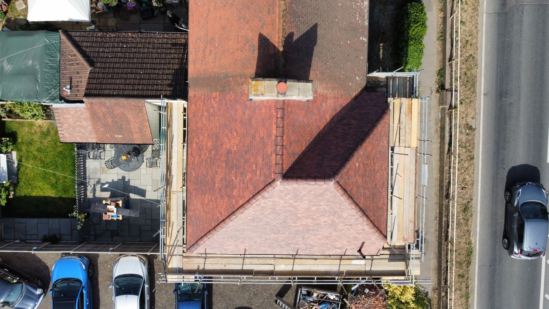 an aerial view of a house with a red tiled roof and scaffolding