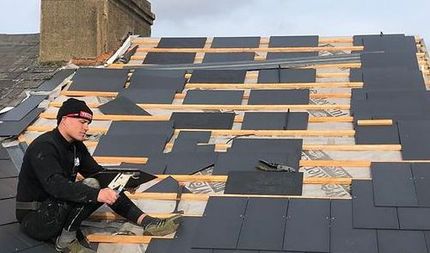 slate roof being installed, man working on roof