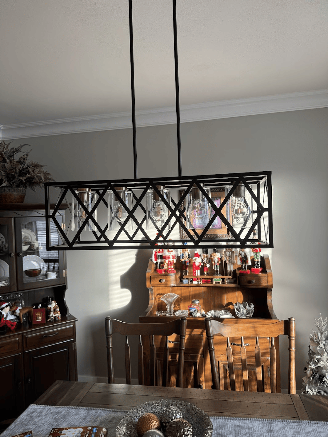 A dining room with a table and chairs and a chandelier hanging from the ceiling.