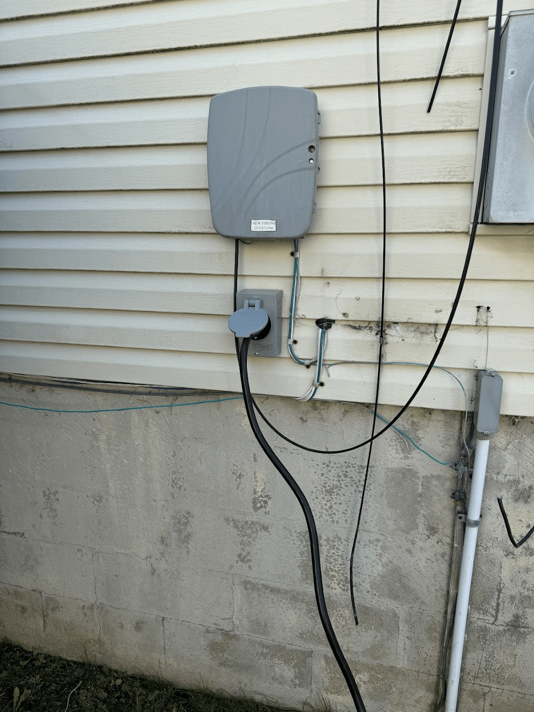 A gray box is attached to the side of a house