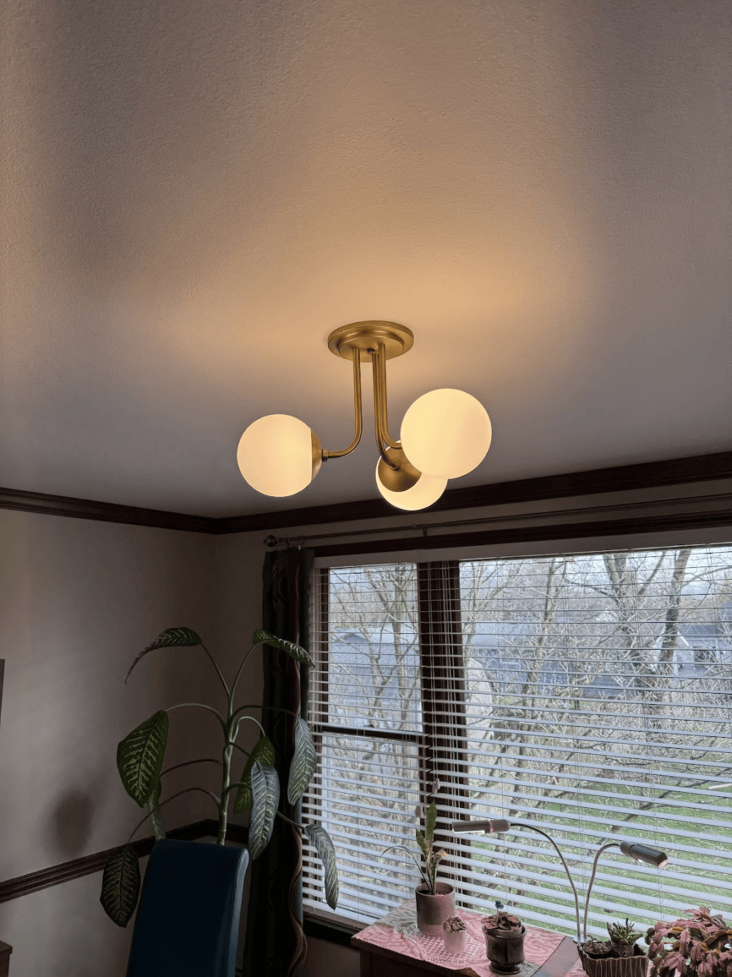 A chandelier is hanging from the ceiling in a living room next to a window.