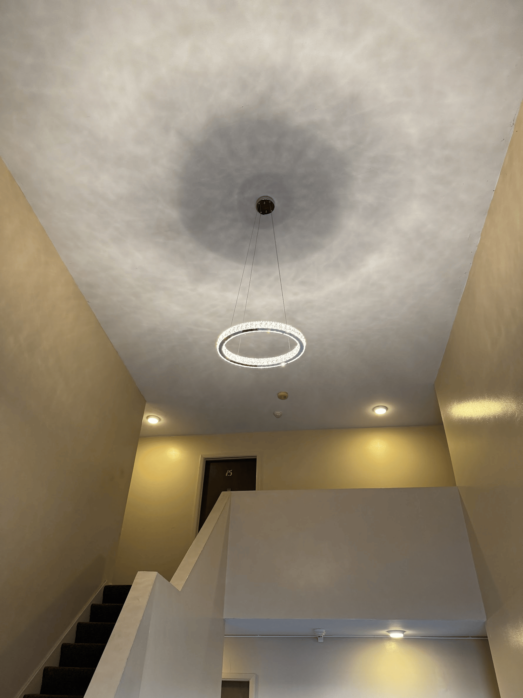 A staircase with a ceiling light hanging from it.