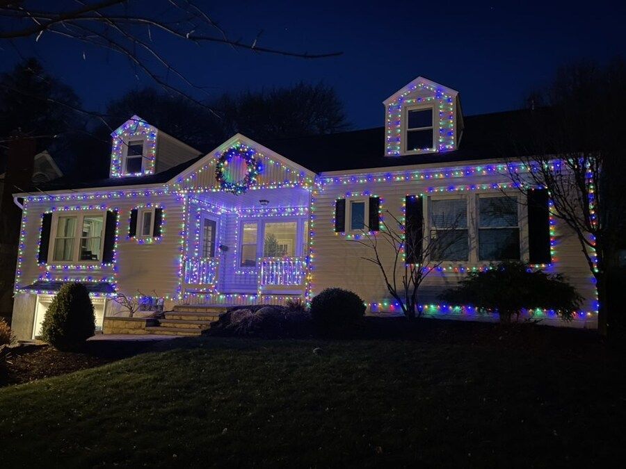 A house is decorated with christmas lights at night.
