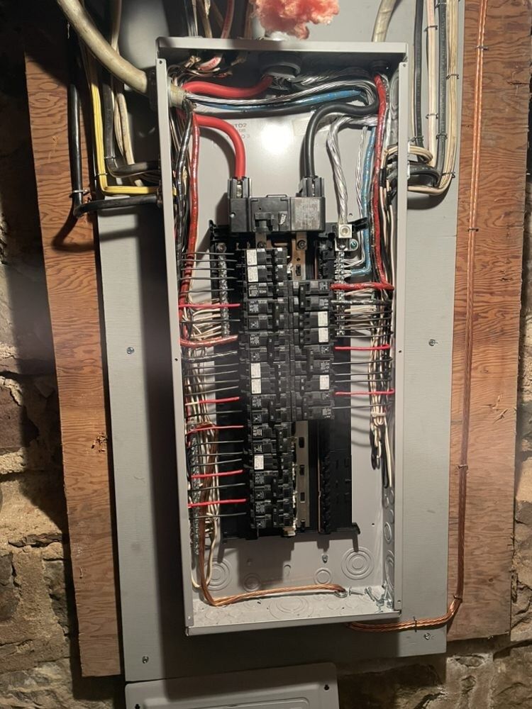 A electrical box is sitting on a wooden wall.