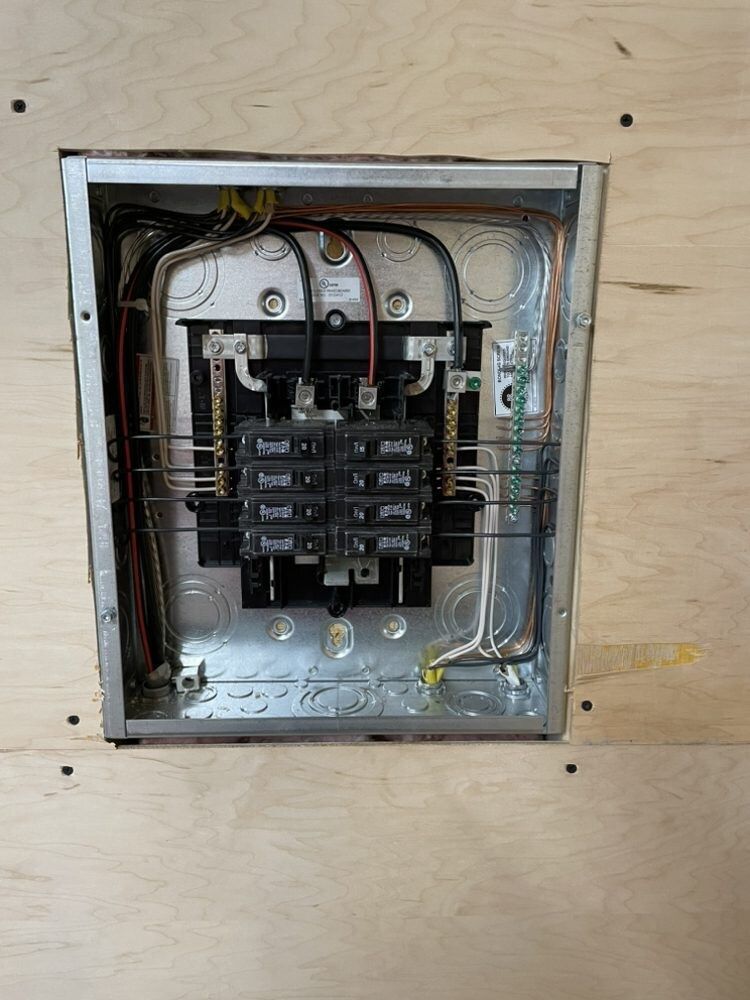 A close up of a electrical box on a wooden wall.