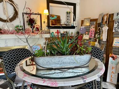 A dining room table with a potted plant on top of it.