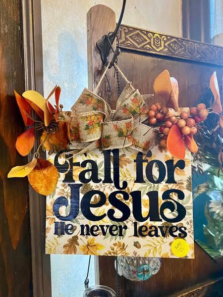 A sign that says `` fall for jesus he never leaves '' is hanging on a wall.