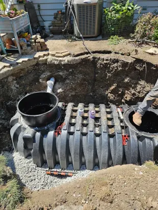 Basement interior with white waterproof barrier, pipes, and sump pump. Cement floor.