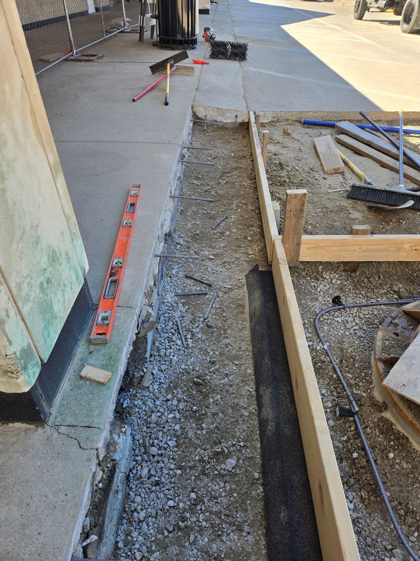 Construction site with a concrete trench. A level and tools are visible.