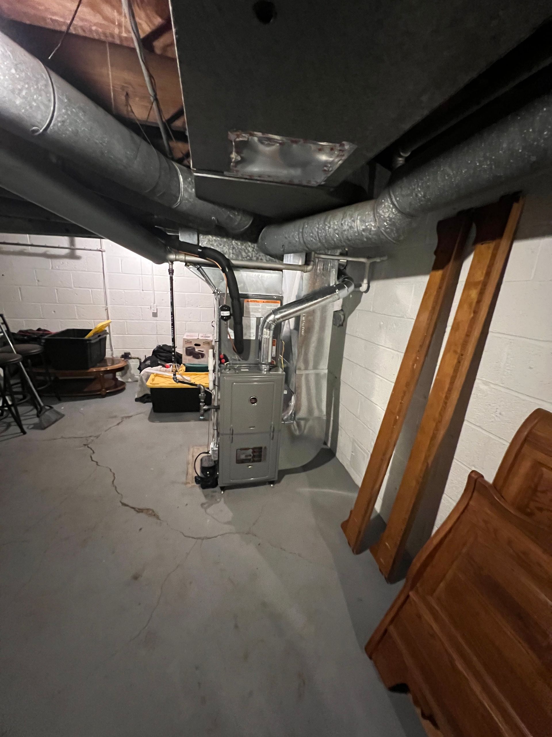 A basement with a furnace and a lot of pipes