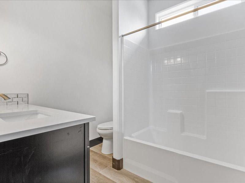 A bathroom with a sink , toilet , shower and bathtub.