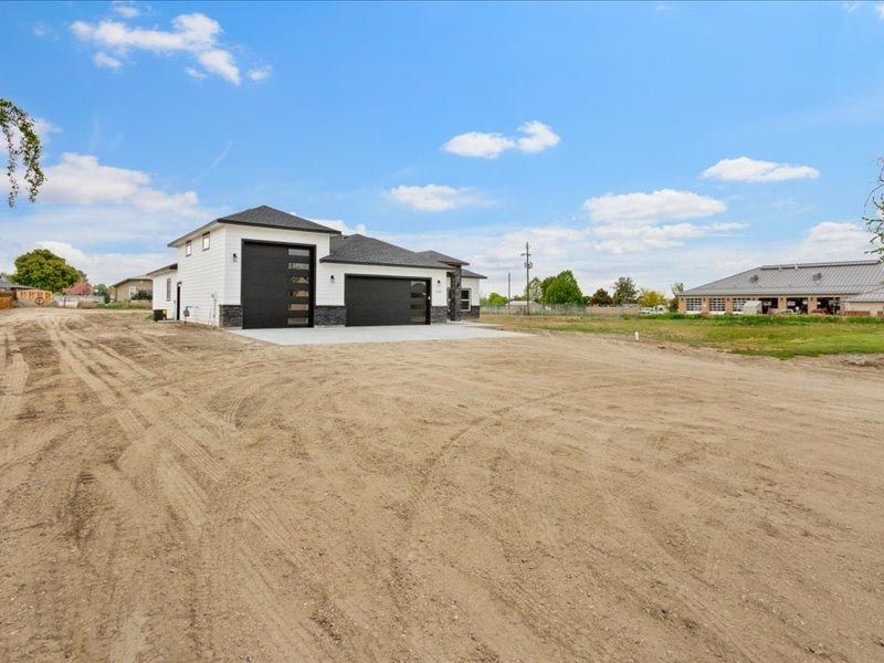 A house is sitting in the middle of a dirt field.