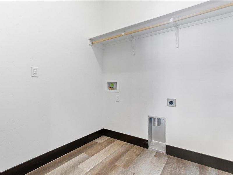 A laundry room with hardwood floors and a washer and dryer.