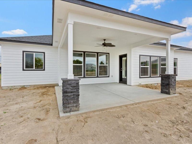A white house with a porch and a ceiling fan