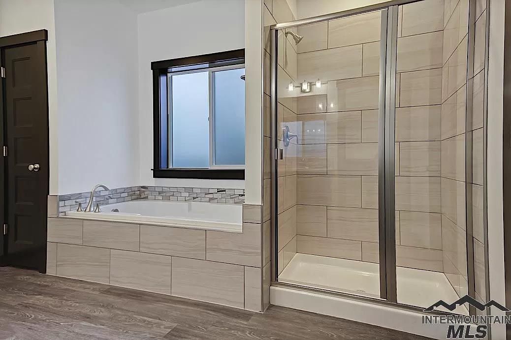 A bathroom with a tub and a walk in shower.