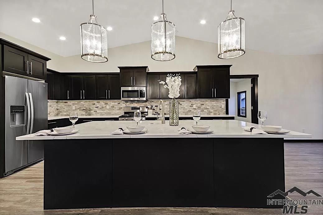 A kitchen with a large island and stainless steel appliances.