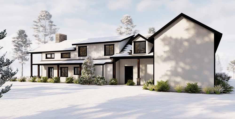 A large white house with black trim is surrounded by snow and trees.