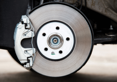 Car disc brake assembly, silver rotor and caliper, with wheel hub and fasteners.