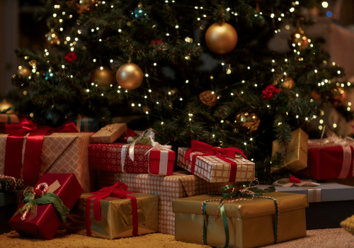 Christmas tree with twinkling lights, surrounded by wrapped gifts.