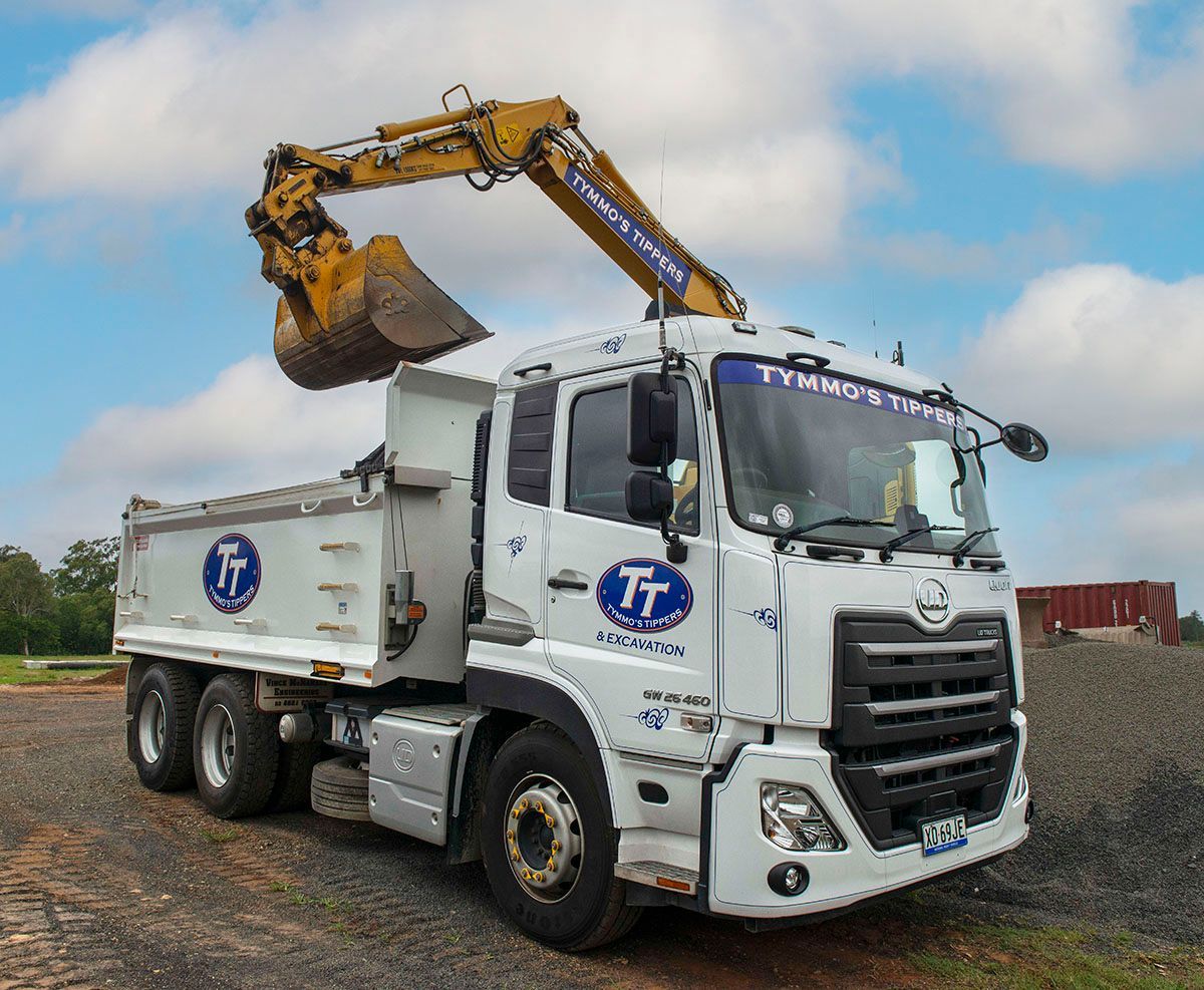 White Tipper Truck Being Loaded by Yellow Excavator — Tymmo's Tippers In Byron Bay, NSW
